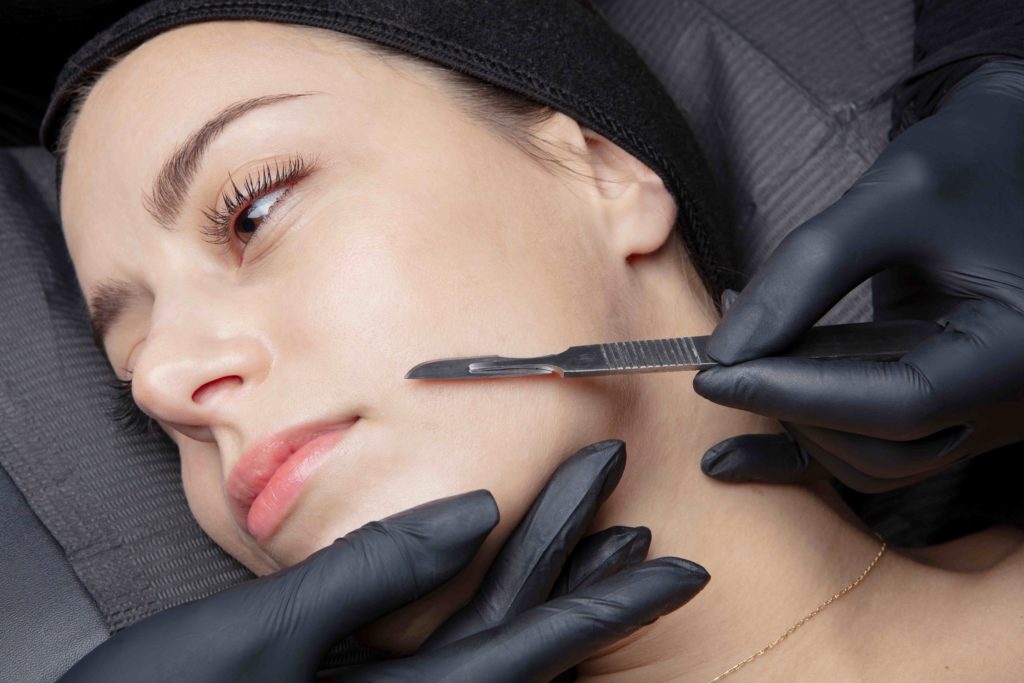 Cosmetologist in a beauty center performing a beauty treatment for the skin of the face with the dermaplaning technique | Bellava Aesthetics in Crestview Hills, KY